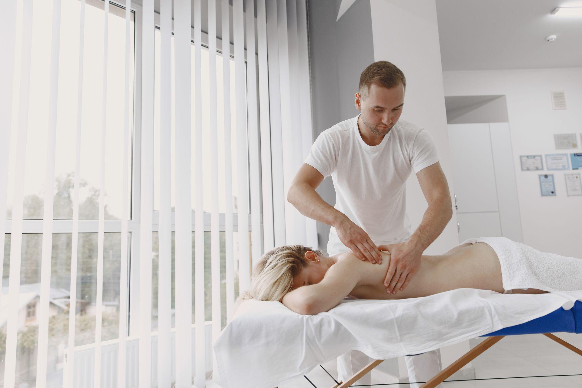Therapeut behandelt den Rücken einer Patientin mit ruhigen Handgriffen